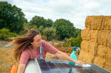 Woman cleaning the side of a camper van while another woman watches and smiles.