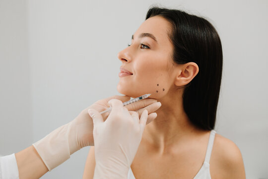 Bruxism injecting for teeth grinding by a cosmetologist. Bruxism injection facial for a treatment with botulinum toxin in an aesthetic medicine clinic.