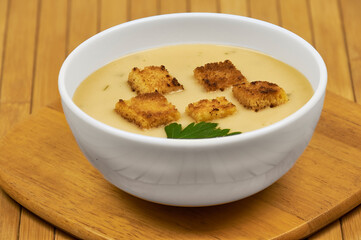 A bowl of asparagus soup in the foreground with rustic decor and background, high studio shots with copy space