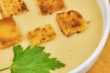 A bowl of asparagus soup in the foreground with rustic decor and background, high studio shots with copy space