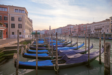 Gondolas lined up at sunset near canal in Venice, Italy showcasing iconic architecture