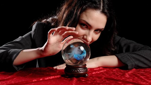 Mysterious woman looking into a crystal ball with a galaxy inside, foretelling the future on a red velvet cloth vector illustration
