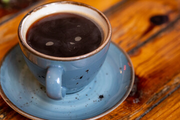 blue cup of coffee wooden table close up