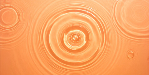 Minimalist scene of calm orange water with a single soft ripple.