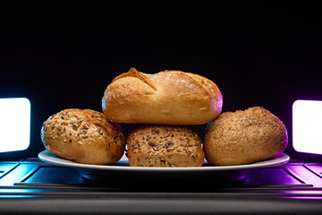 Pile of assorted buns and bagels with soft neon light