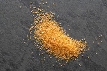Brown granulated sugar scattered on the table - Saccharum officinarum