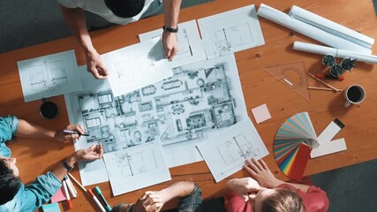 Top view of smart architect engineer team talking about project plan while manager walking at meeting table and start working and analyze building construction and looking at blueprint. Symposium. - Powered by Adobe