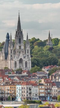 Aerial evening view of Notre Dame de Laeken church spires timelapse in Brussels, Belgium. Neo-gothic architecture surrounded by historic facades, lush green park areas and picturesque urban scenery