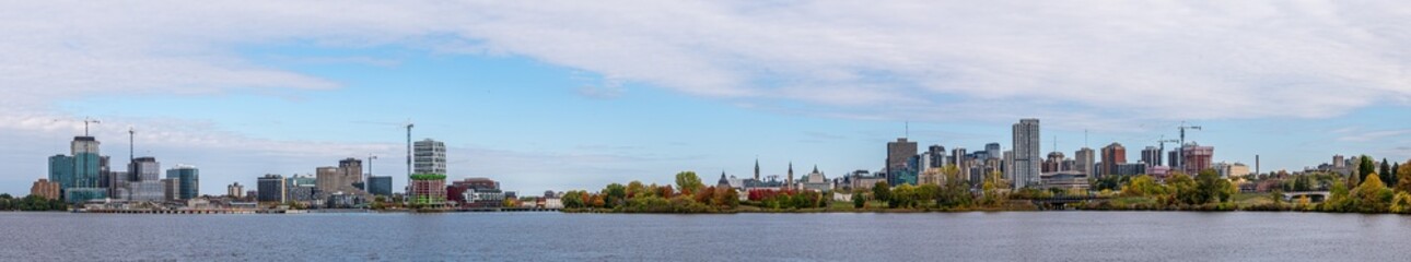 Fototapeta premium Wide high resolution panoramic view of downtown Ottawa, Ontario, and Gatineau, Quebec, across the Ottawa River and colorful autumn trees capture Canada’s National Capital Region (October 2025)