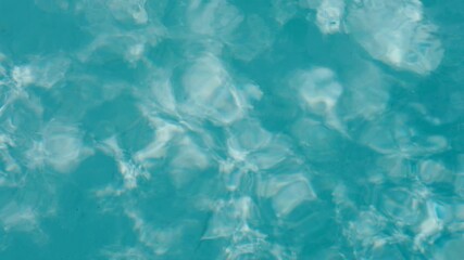 Body of water with soft waves and ripples. Water is clear and blue and surface looks calm but slightly moving. Scene feel fresh and peaceful.