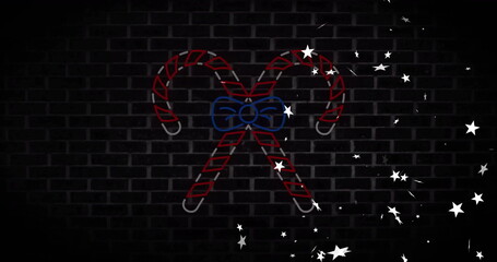 Fototapeta premium Neon candy canes with bow and stars image over dark brick wall
