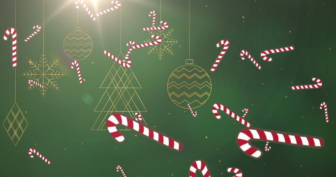 Naklejki Image of candy cane and snow falling over green background