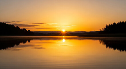 Obraz premium Majestic sunset reflecting on the tranquil lake, with silhouettes of trees and distant mountains creating a breathtaking and peaceful scenery
