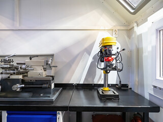 Industrial drill press. Carpentry shop. Table with tools for drilling and milling. Drill press with vice. Versatile lathe. Industrial equipment for small businesses. Carpentry equipment