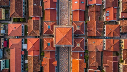 Aerial view of a grid of houses with red roofs and a central square, showcasing urban architecture and organized layout.
