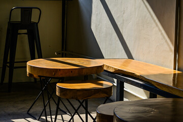 Cafe interior with empty wooden chairs and table. Iron. Photo. Sunlight, sunshine. Black, shadows, dark. round. long. Morning.