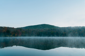 Beautiful Autumn Forest with Mountain Fog and A Lake
