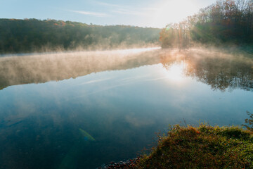 Beautiful Autumn Forest with Mountain Fog and A Lake