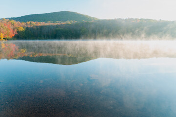 Beautiful Autumn Forest with Mountain Fog and A Lake