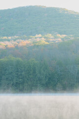 Beautiful Autumn Forest with Mountain Fog and A Lake