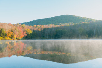 Beautiful Autumn Forest with Mountain Fog and A Lake