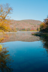 Beautiful Autumn Forest with Mountain Fog and A Lake