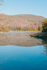 Beautiful Autumn Forest with Mountain Fog and A Lake