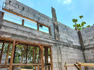 The view of the building of the resident's house in the middle of the rice field. Construction of building of concrete house.