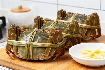 Fresh crabs tied with bamboo strips on a cutting board