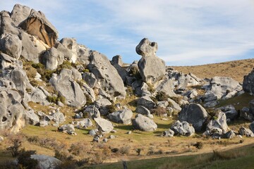 Impressive, scattered limestone boulders dominate the landscape of Castle Hill (Kura Tawhiti), Canterbury, New Zealand, in May 2025. This unique geological wonder is set against a blue sky. © Chonlatit