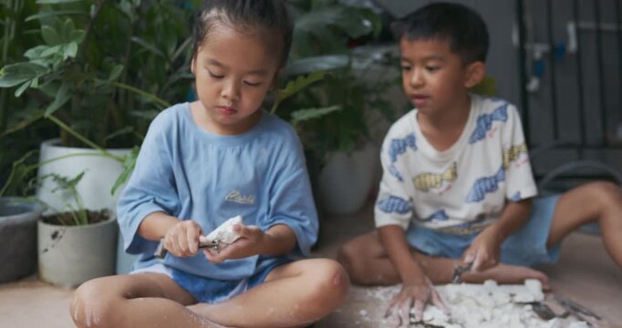 Adorable little boy and girl enjoy dig dinosour fossil toy kids sciene learnning