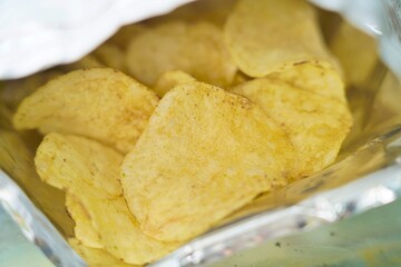 Crispy potato chips inside a foil bag, captured with shallow depth of field