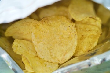 Close-up of crispy potato chips inside foil bag