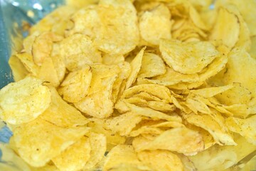 Stack of golden crispy potato chips, layered to showcase texture and crunch