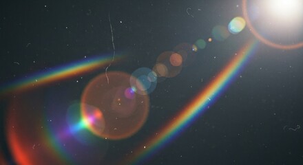 Lens flares and rainbow effect against dark, grainy background with dust/scratches