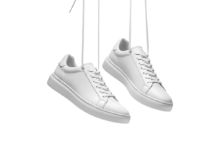 Pair of white leather sneakers hanging by strings isolated on transparent background