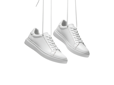 Pair of white leather sneakers hanging by strings isolated on transparent background