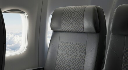 Naklejka premium Airplane cabin seats with a view of clouds and sky from the window.
