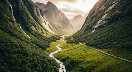 Majestic Green Valley with Winding River and Towering Mountains Under a Dramatic Sunlit Sky Bathed in Golden Hour Light