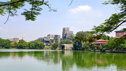 modern building with unique architectural design beside a lake with blue sky, with reflection in the water. the central library of the university of indonesia