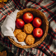 Autumn picnic basket with apples and pumpkin cookies
