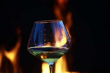 Elegant Glass of Wine against a Cozy Fireplace Background