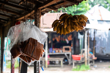 Vibrant bananas and local sweets hanging at the rustic roadside marketplace, offering a taste of...