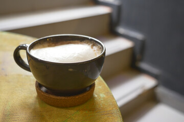 Coffee mug placed on a table near stairs