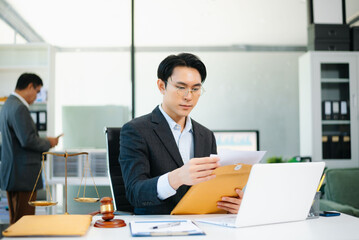 Asian business team and lawyers discussing contract papers sitting at the table. Concepts of law, advice, legal services.