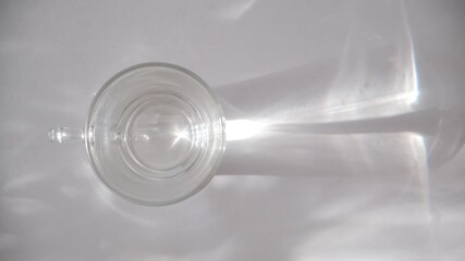 Glass cup with pure water, sunlight refraction in the water. Early morning, Start new day. Drinking to avoid dehydration, manage weight and care for healthy habits. Water balance and caring for skin