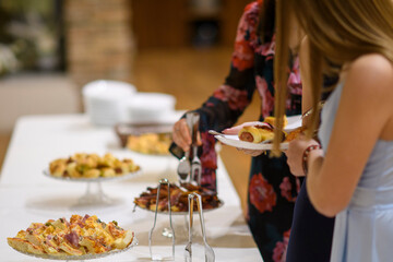 Guests select delicious appetizers from a well catered buffet table during a special event or party celebration