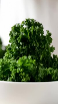 Curly Kale Being Placed Into White Bowl