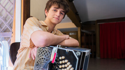 Young musician poses confidently with bandoneon in a tango music rehearsal