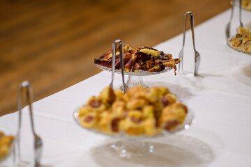 Delicious Sweet Pastries and Desserts Displayed on a White Tablecloth Ready for a Celebration or Party Serving as an Appetizing Food Buffet Experience